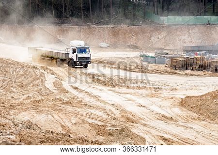 Grodno, Belarus - April 2020: Heavy Laden Multi-ton Truck Maz White Cab And Gray Body Arrives At Con