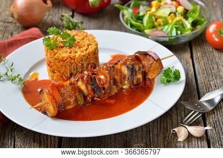 Hearty Shashlik Skewer In A Spicy Sauce With Djuvec Rice And Mixed Side Salad