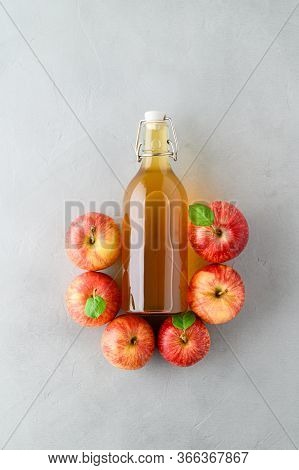 Homemade Fermented Kombucha Or Cider In A Bottle And Red Apples On A Gray Stone Background. A Health