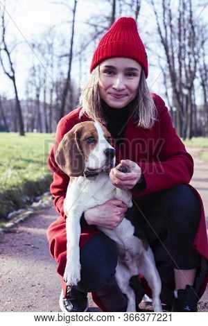 Pretty Young Girl In Redd Coat Playing With Dog Outside In Green Park, Lifestyle People Concept