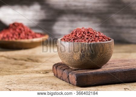 Annatto Seeds In Bowl On Wooden Background