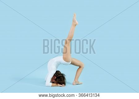 Talanted Little Girl In A White Leotard Doing Backbend With Raised Leg