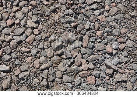 Stone Rubble For Use As A Background Or Texture With A Cement Stain. Gray Light Stones On A Dirt Roa