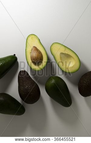 Sliced And Whole Fruits Of Different Varieties Of Green And Brown On A Light Background.