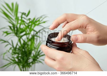 Shea Butter In Jar, Cosmetic Product For Moisturizing Skin And Hair. Female Hand Holds Container Wit