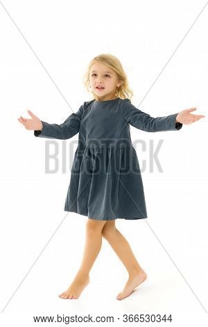 Beautiful Little Girl In A Dress Is Spinning. Concept Of Happy Childhood, Dancing, Holidays. Isolate