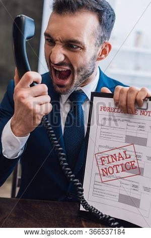 Aggressive Collector Shouting On Handset And Holding Documents With Foreclosure And Final Notice Let