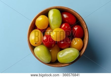 Different Sorts Of Small Tomatoes On Colored Background