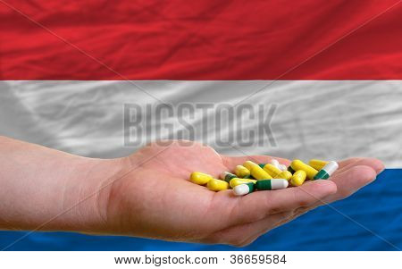 Holder piller i hånden foran Holland nationale Flag