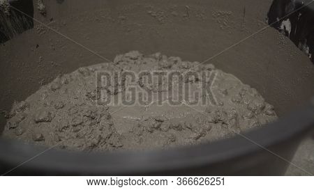 Bucket With A Solution. Knead The Solution With A Mixer In A Bucket Of Cement And Sand