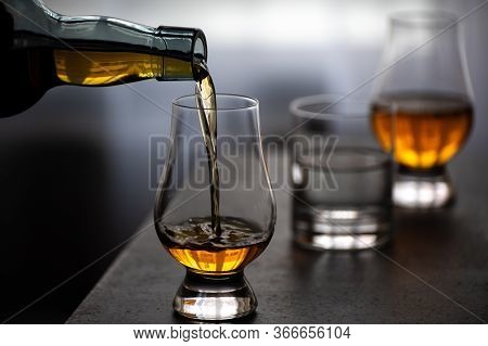 Pouring In Tulip-shaped Tasting Glass Scotch Single Malt Or Blended Whisky And Glas Of Water