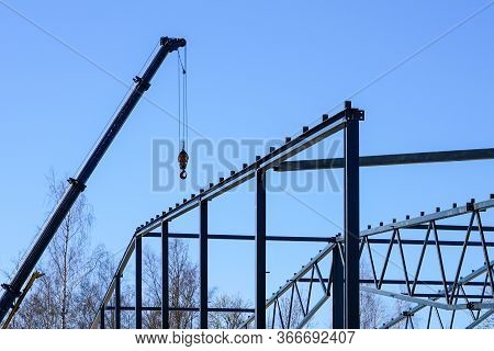 Truck Mounted Crane With A Telescoping Boom At Constructing A Metal Carcas Of A New Building