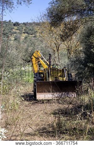 Excavator Single-bucket  For Harvesting Falling Stones On The Roadway In The Mountains, Is Parked At