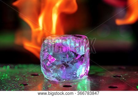 Close Up Big Melting Piece Of Ice On The Bar Counter In Fireflames On It, Preparation For A Cocktail