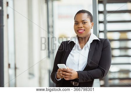 Confidence. African-american Businesswoman In Office Attire Smiling, Looks Confident And Happy, Busy