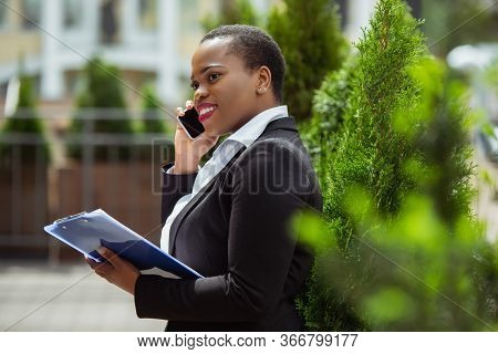 Communication. African-american Businesswoman In Office Attire Smiling, Looks Confident And Happy, B