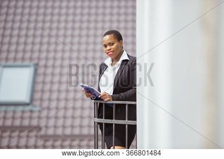 Confidence. African-american Businesswoman In Office Attire Smiling, Looks Confident And Happy, Busy