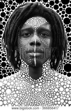 Portrait of young african man with dreadlocks and traditional face paint looking straight into the camera 
