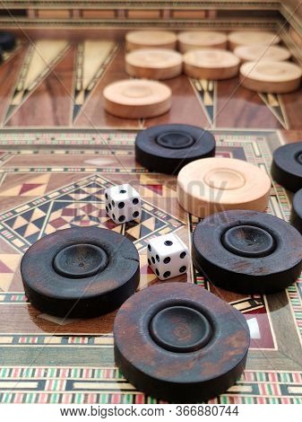 Backgammon With Wooden Inlay. Wooden Backgammon Board Game Of Pearl Inlaid On Brown Background.