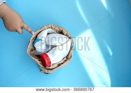 Paper Bag With Plastic Bottle On A Solid Blue Background For Recycle Waste. Waste Separation Concept