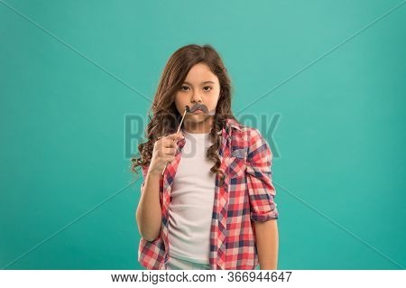Serious Kid With Funny Party Moustache. School Girl Ready For Fun. Happy Childhood. Child Try To Mak
