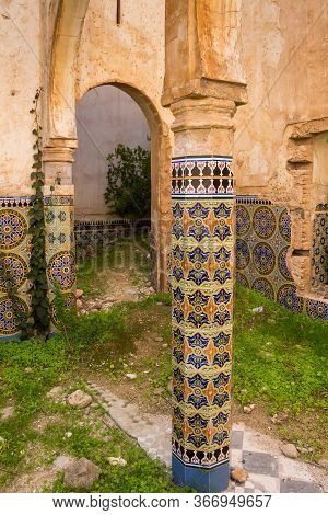 Yard Of A Ruin Of An Abandoned Building. Decorative Columns With Traditional Painted Tiles With Geom