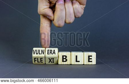 Vulnerable Or Flexible Symbol. Businessman Turns Wooden Cubes And Changes Words 'vulnerable' To 'fle