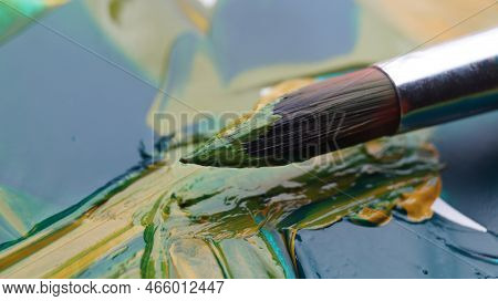 Brush On Artist's Palette With Mixed Paints, Closeup