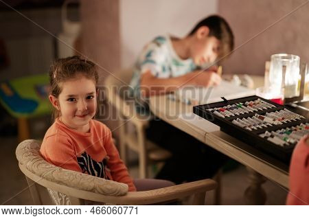 Family Spending Time Together During An Energy Crisis In Europe Causing Blackouts. Kids Drawing In B