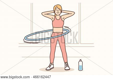 Toned Young Woman In Sportswear Training At Home. Happy Fit Girl Spinning Hula-hoop Engaged In Worko