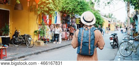 Happy Solo Traveler Sightseeing At Hoi An Ancient Town In Central Vietnam, Man Traveling With Backpa