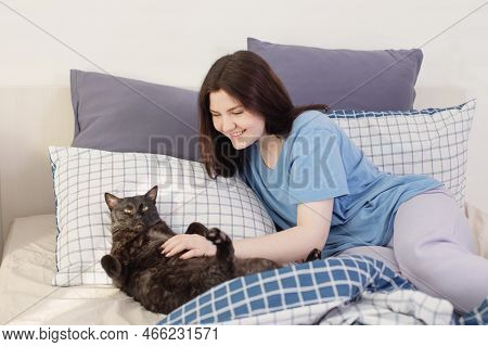 Happy Teen Girl With Black Cat In White Bedroom