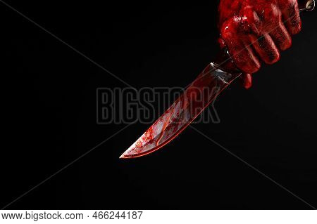 A Man With Bloody Hands Brandishes A Knife On A Black Background.