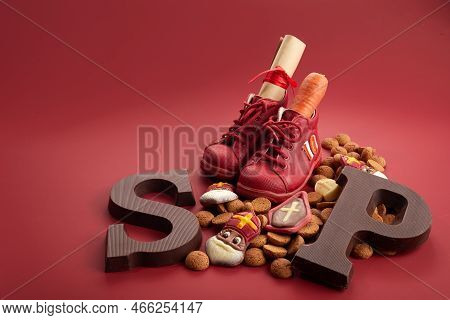 Saint Nicholas - Sinterklaas Day With Shoe, Carrot And Traditional Sweets On Red Background