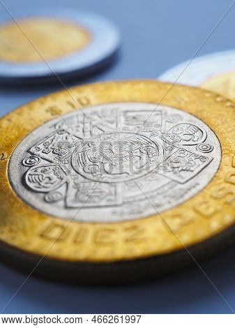 Mexican Coins Lie On Blue Surface. Coin Of 10 Ten Pesos Close-up. Peso Of Mexico. News About Economy