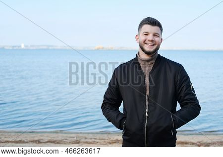 A Young Man Stands On The Beach With A Lake In The Background. Stress-free Concept. Slow Living. Enj