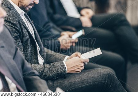 Businessman Hands Holding Meeting Brochure With Program And Schedules Of Business Conference Lecture