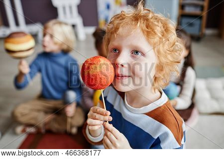 Adorable Gingerhaired Boy Holding Planet Model Of Mars By His Face While Studying Astronomy At Lesso