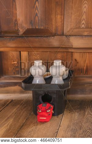 Small Red Mask Of Tengu God Of The Mountains In Front Of A Black Tray Sanpou Made Of Cypress Wood To