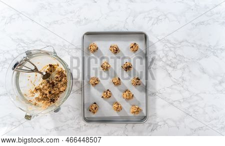 Flat Lay. Scooping Cookie Dough With Dough Scoop Into A Baking Sheet Lined With Parchment Paper To B