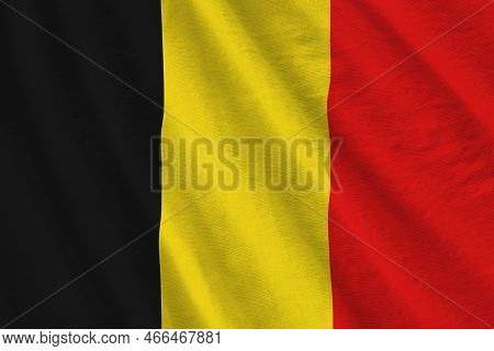 Belgium Flag With Big Folds Waving Close Up Under The Studio Light Indoors. The Official Symbols And