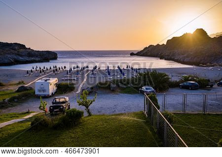 Amazing Skinaria Sandy Beach In The Sunset Or Dusk With Parked Cars.