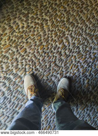 Man Stepping On Pebbles Floor. Traditional South Spanish Flooring Techique