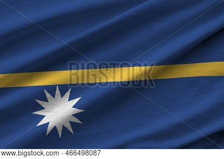 Nauru Flag With Big Folds Waving Close Up Under The Studio Light Indoors. The Official Symbols And C