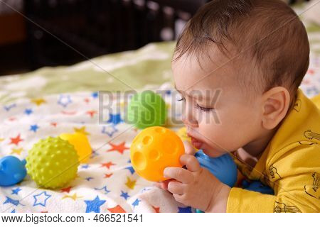 Cute Adorable Newborn Baby Playing With Colorful Rattle Toy. Baby With Teether. Six Months Old Lovel