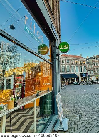 The Hague, Netherlands - December 16 2021 : Cyclists Are Passing By The Store Front Of A Tex Mex Res