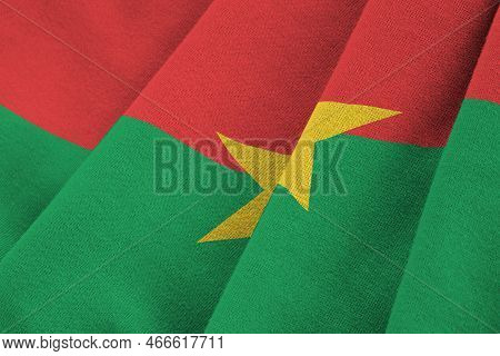 Burkina Faso Flag With Big Folds Waving Close Up Under The Studio Light Indoors. The Official Symbol