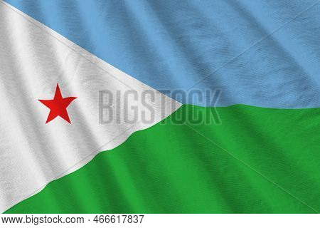 Djibouti Flag With Big Folds Waving Close Up Under The Studio Light Indoors. The Official Symbols An