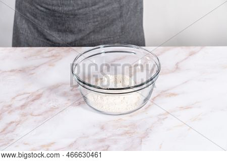 Mixing Ingredients In A Large Glass Mixing Bowl To Bake Apple Sharlotka Muffin.