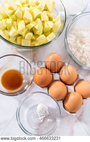 Measured Ingredients In A Glass Mixing Bowl To Prepare Apple Sharlotka Muffin.